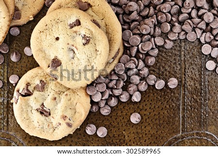 Chocolate chips cookies with loosely scattered chocolate chips over a rustic background. Perfect for the May 15th National Chocolate Chip Day!