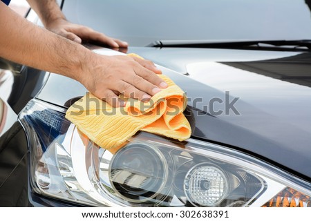 A man cleaning car with microfiber cloth, car detailing (or valeting) concept Royalty-Free Stock Photo #302638391