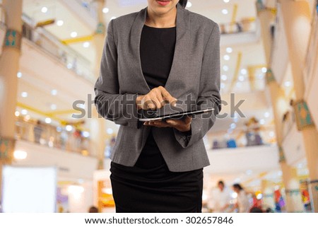 Woman using tablet in shopping mall.