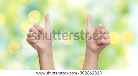 gesture, like, success, and people body parts concept - woman hands showing thumbs up over blue sky and clouds background