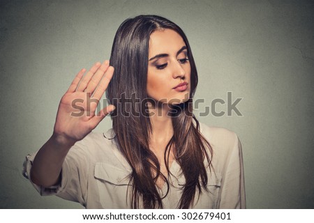 Closeup portrait young annoyed angry woman with bad attitude giving talk to hand gesture with palm outward isolated grey wall background. Negative human emotion face expression feeling body language Royalty-Free Stock Photo #302679401