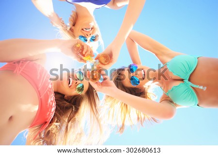 A picture of a group of friends drinking beer on the beach