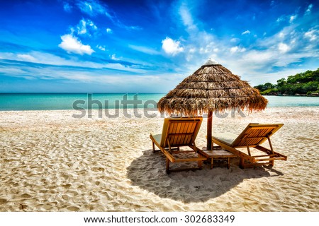 Vacation holidays background wallpaper - two beach lounge chairs under tent on beach. Sihanoukville, Cambodia Royalty-Free Stock Photo #302683349