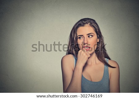 Closeup portrait nervous looking young woman biting her fingernails craving something anxious isolated grey background copy space. Negative human emotion facial expression body language perception Royalty-Free Stock Photo #302746169