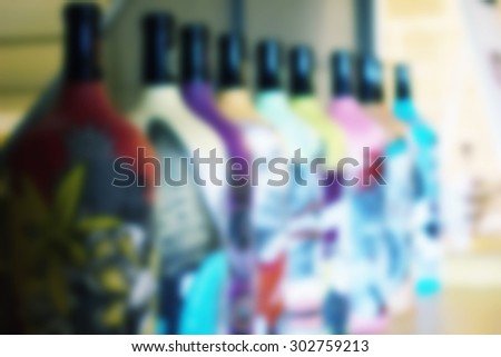 Colorful bottles with different pictures on ti's front side blurred background