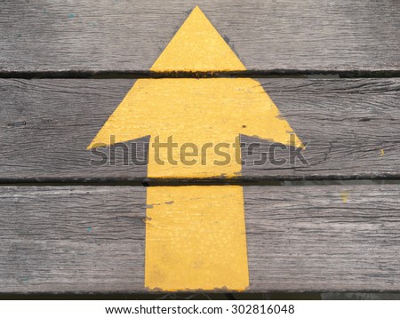 The yellow arrow on a wooden board