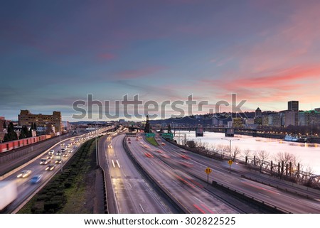 Portland Oregon rush hour traffic with city skyline along Interstate freeway during sunset evening