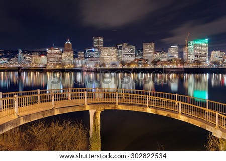 Portland Oregon downtown city skyline from pedestrian bridge along Willamette River at night