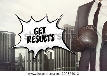 Get results text with businessman wearing boxing gloves on cityscape background