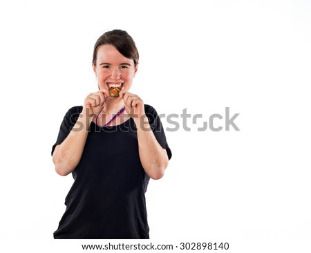 Young girl biting a gold medal isolated on white background