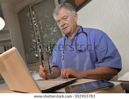Portrait of smiling doctor at laptop in office