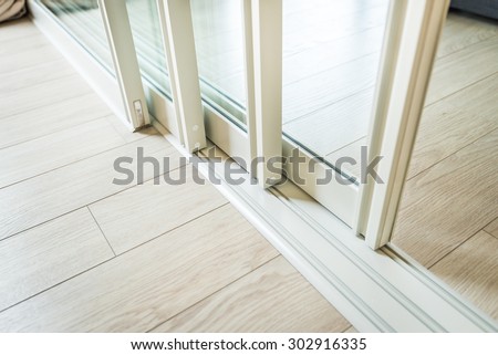 sliding glass door detail and rail embed in wooden floor Royalty-Free Stock Photo #302916335