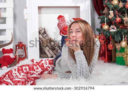 The girl in a Christmas tree interior , fireplace , red and white color