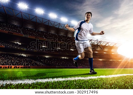 Soccer player in action on sunset stadium background panorama