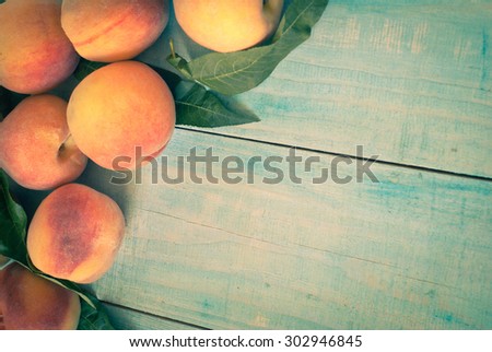 Few ripe peaches on a wooden table. Image tinted
