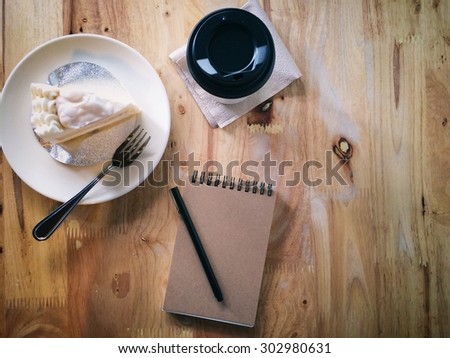 Top view of coffee and stationery mock up set with coffee, cake, notebook and pen