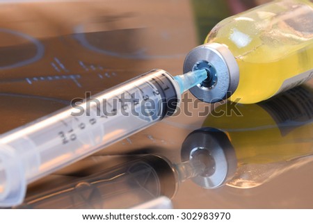 Glass Medicine Vials with botox, hualuronic, collagen or flu Syringe on x-ray film over doctor table (shallow DOF) Royalty-Free Stock Photo #302983970