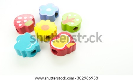 Colourful wooden block of cute birds, owl, tree, flower and mushroom. Isolated on white background. Slightly de-focused and close-up shot. Copy space.