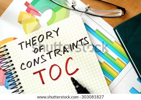 Words Theory of Constraints  TOC  on the notepad and charts. Royalty-Free Stock Photo #303081827