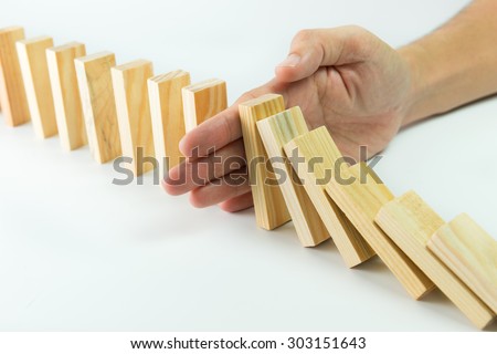 Solution concept with hand stopping wooden blocks from falling in the line of domino Royalty-Free Stock Photo #303151643