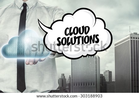 Cloud solutions text on cloud computing theme with businessman on cityscape background