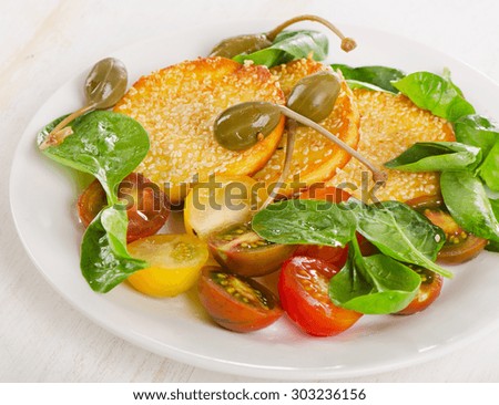 Slices of halloumi cheese with capers and fresh vegetables. Selective focus