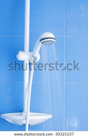 White modern shower and drops of water on blue tiling background