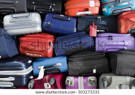 Suitcases multicolor stacked for transport one above the other Royalty-Free Stock Photo #303273335