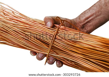 Man with dirty hands holding a roll of copper wire isolated on white