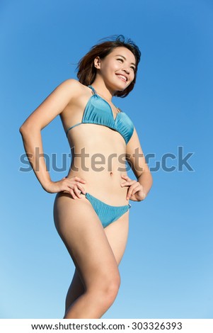 Happy girl wear bikini at sea beach and smile, asian beauty