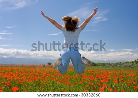 young woman  jumps on poppy field