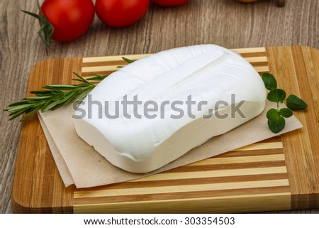 Traditional Greek cheese - Feta with herbs on the wood background