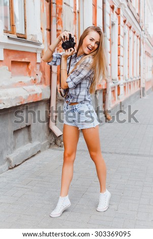 
Outdoor Young hipster girl going crazy, have positive surprised emotions, screaming and laughing, bright summer outfit. close her face by her hands.make travel pictures on her Europe trip