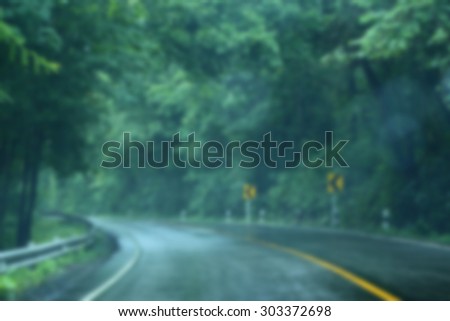 Blurred scene of wet road in the forest after rain.