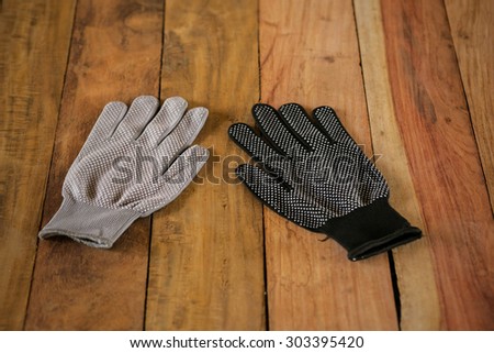 Black, white gloves put on the wood.