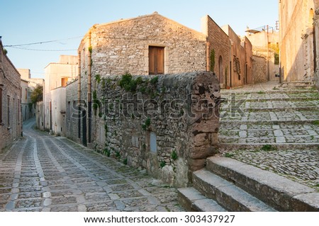 Perspective of some typical narrow alleys in Erice, a small picturesque village in the province of Trapani, West Sicily Royalty-Free Stock Photo #303437927