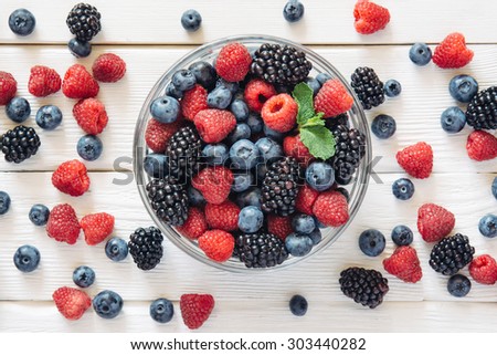 Healthy mixed fruit and ingredients with strawberry, raspberry, blueberry, blackberry from top view Royalty-Free Stock Photo #303440282