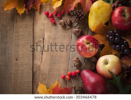 Peaceful Fall Fruit, Leaf, Acorn Still Life arrangement on Rustic Wood Board Table Background with room or space for copy, text, your words.  Horizontal dark, warm tone, looks good as vertical.