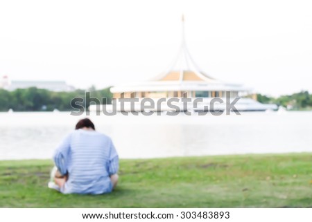 blurry a woman sits alone and feels depressed in a public park