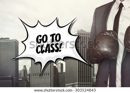 Go to class text with businessman wearing boxing gloves on cityscape background