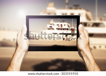 Man taking photos with a digital electronic tablet.