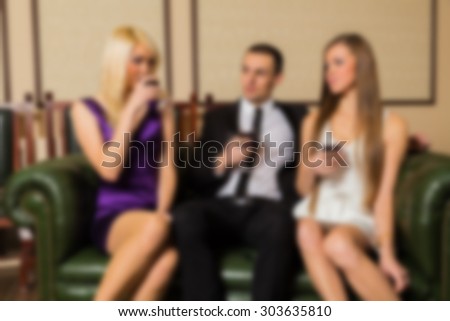 The company of people on a sofa talking. blurred Background