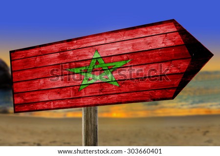 Marocco Flag on wooden table sign on beach background