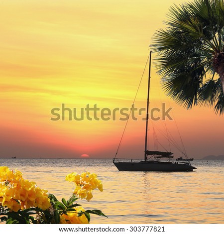 seascape scenic sunset and anchored boat with deflated sails off the coast of Thailand