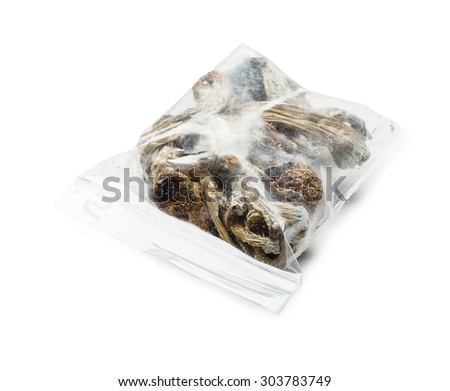 Dried magic mushrooms sealed in a ziplock bag, isolated on white.