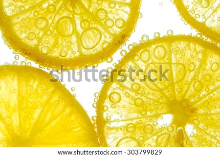 Fresh lemon slice in water with bubbles on white background Royalty-Free Stock Photo #303799829