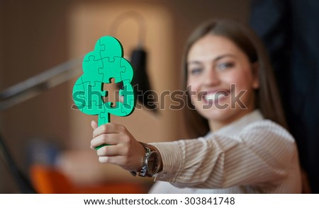 business woman with tree puzzle looking happy and smiling