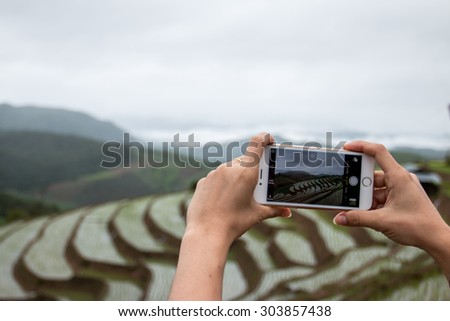 Smart phone take a photo of Pa Pong Piang rice terraces, Chiang Mai, Thailand.