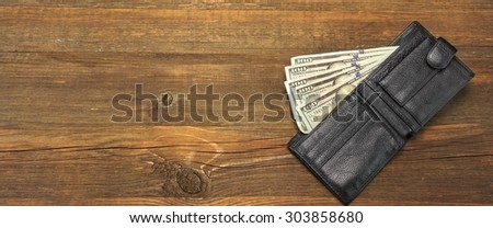 High Angle View Of Modern Black leather Men's Wallet With Dollar Cash On The Old Rough Wood Textured Background With Copy Space