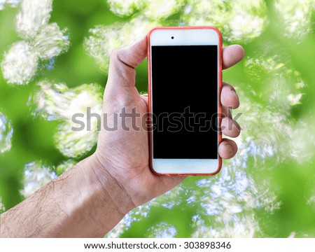 Hand holding touch screen mobile phone isolated green blurry background